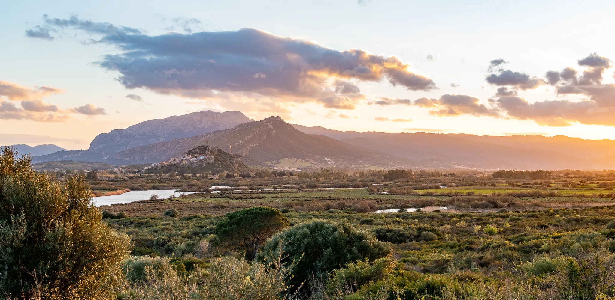 Sunset over the historic town with tower and castle, spring nature Sardinia.